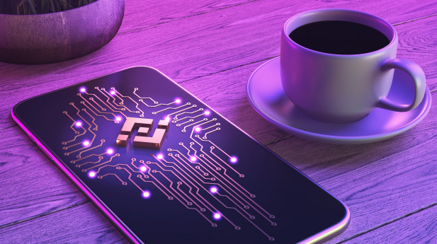 Celular com conceito da Binance próximo a uma xícara de café